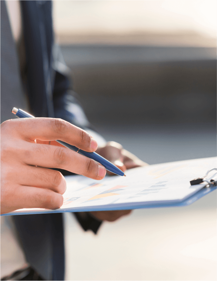 A businessman holding a pen above a sheet of paper